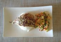 Un plato blanco con un trozo de pescado y una ensalada. en Palawan SandCastles, en Minuit