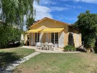 a small yellow house with chairs and an umbrella at Villa à 10m de la plage de sable in Vallauris