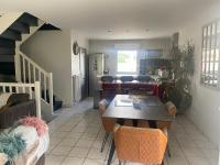 a kitchen and living room with a table and chairs at Agréables chambres dans maison suspendue in Saint-Étienne