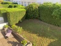 a garden with bushes and a bench in a yard at Agréables chambres dans maison suspendue in Saint-Étienne