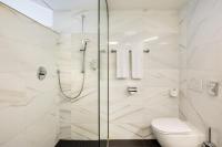a white bathroom with a shower and a toilet at Austria Trend Hotel Congress Innsbruck in Innsbruck