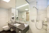 a bathroom with a sink and a shower and a toilet at Austria Trend Hotel Congress Innsbruck in Innsbruck
