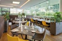 a restaurant with tables and chairs and windows at Austria Trend Hotel Congress Innsbruck in Innsbruck