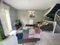 a living room with a couch and a staircase at Agréables chambres dans maison suspendue in Saint-Étienne