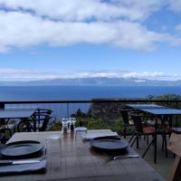 a wooden table with tables and chairs on a balcony at Lava Homes in Santo Amaro