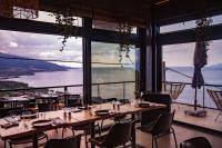 a restaurant with tables and chairs and large windows at Lava Homes in Santo Amaro
