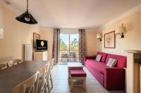 a living room with a red couch and a table at Les Coteaux de Pont Royal en Provence - maeva Home - Appartement 3 pièces 6 214 in Mallemort