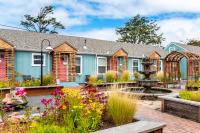 a home with a garden with flowers and a fountain at Inn at Haystack Rock in Cannon Beach