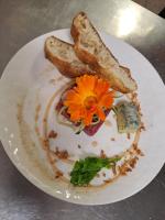 Un plato de comida con pan y una flor encima. en Azienda Agrituristica Ai Prai, en Riese