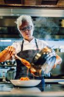 Uma mulher está a preparar comida numa cozinha. em Clarion Hotel Arlanda Airport Terminal em Arlanda
