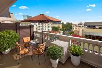 a balcony with a table and chairs and an umbrella at Hotel de l'Opera Hanoi - MGallery in Hanoi