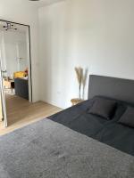 a bedroom with a large bed and a mirror at Chic &amp; moderne appartement - proximité métro in Asnières-sur-Seine