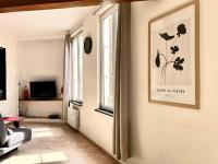 a living room with a picture of flowers on the wall at L&#39;appartement du Centre in Chalons en Champagne