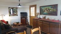 a living room with a couch and a tv at CHEZ ANTOINE in Saint-Pierre-dels-Forcats