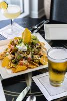 Un plato de nachos y una bebida en una mesa. en The Pensacola Beach Resort, en Pensacola Beach