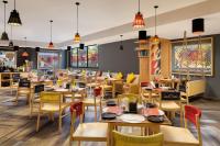 un ristorante con tavoli e sedie in legno di Ginger Mumbai Airport a Mumbai