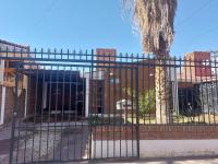 una puerta frente a un edificio con un árbol en Casa Silvia - Zona Palmares, en Godoy Cruz