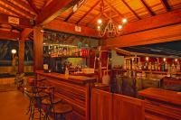 a bar in a restaurant with chairs and alcohol bottles at Hotel Pousada Villa Itália Olímpia in Olímpia