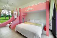 a pink bedroom with a bed and a slide at Fairy Story Village Farm B&amp;B in Dongshan