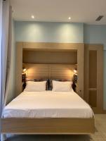 a bedroom with a large bed with a wooden headboard at Mes à Moi in Pezenas - Studio &amp; patio privatif - O Pitchoun in Pézenas