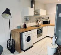 a kitchen with a washing machine and a stove at Le Berceau Vert in Marseille