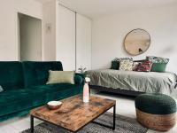 a living room with a green couch and a table at Le Berceau Vert in Marseille