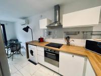 a kitchen with white cabinets and a stove top oven at Le Berceau Vert in Marseille