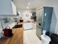 a kitchen with a stainless steel refrigerator and white cabinets at Le Berceau Vert in Marseille