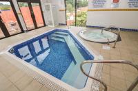 a large swimming pool with a tub in a building at Pugwash Cottage in Falmouth