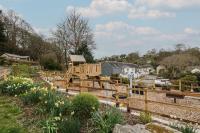 a wooden playground in a garden with flowers at Pugwash Cottage in Falmouth