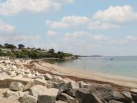 a beach with rocks and people on the water at Pugwash Cottage in Falmouth