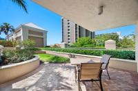 eine Terrasse mit Tisch und Stühlen und ein Gebäude in der Unterkunft Marco Beach Ocean Suites in Marco Island
