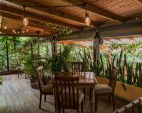 Un patio con mesa y sillas y plantas. en Hotel Las Farolas, en Antigua Guatemala