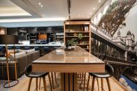 a bar with a table and chairs in a room at Courtyard by Marriott Paris Porte de Versailles in Issy-les-Moulineaux