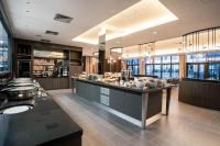 a restaurant with a counter with food on it at Courtyard by Marriott Paris Porte de Versailles in Issy-les-Moulineaux