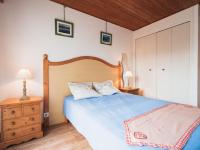 a bedroom with a blue bed with two pillows at Appartement Les Gets, 2 pièces, 3 personnes - FR-1-671-120 in Les Gets
