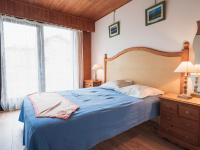a bedroom with a blue bed and two windows at Appartement Les Gets, 2 pièces, 3 personnes - FR-1-671-120 in Les Gets