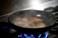 un filete cocinado en una sartén en una estufa en 宿坊　心月, en Arita