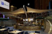 ein Restaurant mit einer Bar mit Tischen und Stühlen in der Unterkunft Hilton Club Elara Las Vegas in Las Vegas