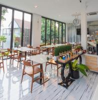 een restaurant met tafels, stoelen en ramen bij VeeVaree Riverkwai Resort in Ban Kaeng Raboet