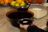 Eine Person, die einen Löffel in einer Schüssel mit Soße hält. in der Unterkunft Pousada e Restaurante Del Miro in Nova Pádua