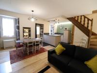 a living room with a black couch and a kitchen at Gîte Fontanges, 4 pièces, 6 personnes - FR-1-742-413 in Fontanges