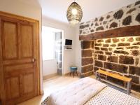 a bedroom with a stone wall and a wooden door at Gîte Fontanges, 4 pièces, 6 personnes - FR-1-742-413 in Fontanges