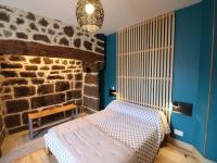a bedroom with a bed and a stone wall at Gîte Fontanges, 4 pièces, 6 personnes - FR-1-742-413 in Fontanges