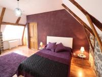 a bedroom with a bed with purple sheets and a wall at Gîte Fontanges, 4 pièces, 6 personnes - FR-1-742-413 in Fontanges