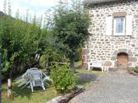 a table and chairs in front of a stone building at Gîte Fontanges, 4 pièces, 6 personnes - FR-1-742-413 in Fontanges