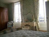 a bedroom with a bed and a dresser and a mirror at Manoir Angle in Blanzay-sur-Boutonne