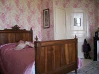 a bedroom with a bed and pink floral wallpaper at Manoir Angle in Blanzay-sur-Boutonne