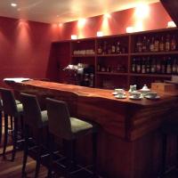 Una gran barra de madera en un restaurante con sillas en Hotel Tunquelén, en San Carlos de Bariloche