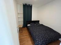 - une chambre avec un lit noir et un rideau bleu dans l&#39;établissement Charmant appartement avec balcon proche du centre., à Périgueux